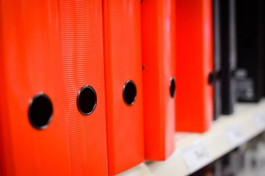 Close up on multicolored office folders on the bookshelf backgrounds. Many working stationery, stacked records. Different color spectrum documents. Educational or financial file-box object supplies