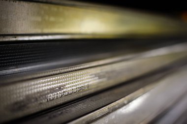 Çelik kaplı alüminyum profili kapatın. Endüstriyel yapı konsepti. Uzayı kopyala Gri renkli metal deste yığını, fabrika üretim teknolojisi deseni