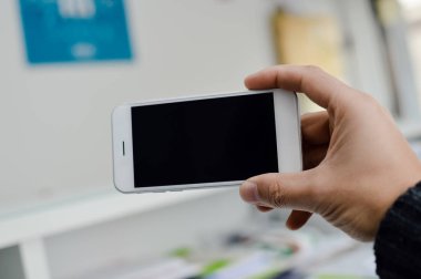 Metin mesajı veya içerik mockup arka plan reklam için boş boşaltmak ekrana sahip cep telefonu kullanarak elde kapatın. Profesyonel ödeme teknolojisi, oyun oynama, video filme veya fotoğraf