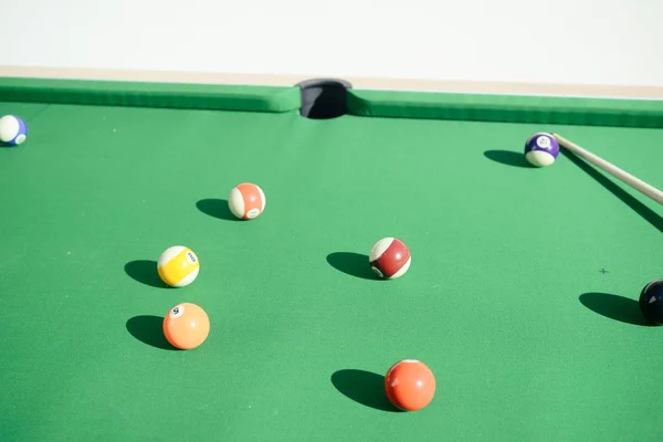 Closeup on billiard balls on green pool table entertainment background