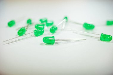 Beyaz bir yüzeye saçılmış yeşil LED 'ler, devreler ve teknoloji için elektronik bileşenler..