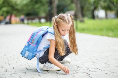 Çocuk okul asfalt tebeşir ile boyar. Okul, eğitim, eğitim, dostluk, çocukluk kavramı