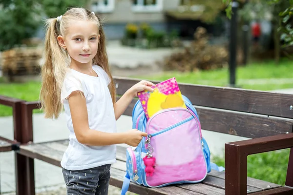 Küçük bir kız kitapları okul çantasında yatıyor. Okul, eğitim, eğitim, dostluk, çocukluk kavramı