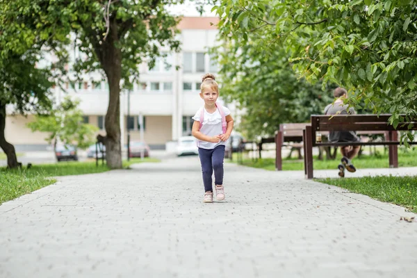 Ein Kleines Mädchen Läuft Mit Einem Rucksack Die Straße Hinunter — Stockfoto