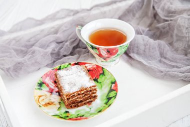 Çikolatalı kek ve bir bardak sıcak çay bir tepsi. Yemek ve tatlı kavramı.