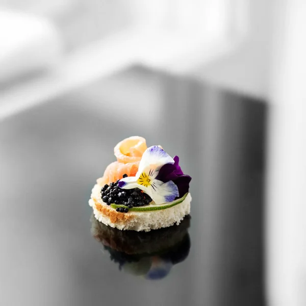 Delicious appetizer with fish and edible flowers. Concept for food, restaurant, menu, catering