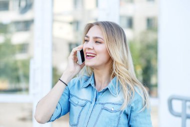 Genç kız sokakta telefonda konuşuyor. Yaşam tarzı, kentsel, iş kavramı