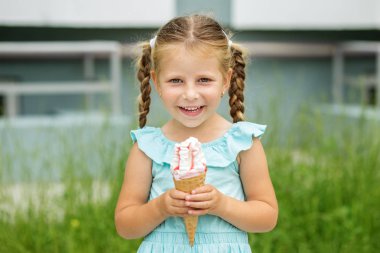 Küçük gülümseyen kız açık havada yürüyüş ve dondurma yemek. Çocukluk, yaz yaşam tarzı, gıda kavramı.