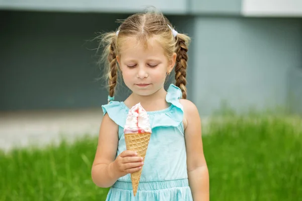 Little child with ice cream on the street. The concept of childhood, lifestyle, food, summer.