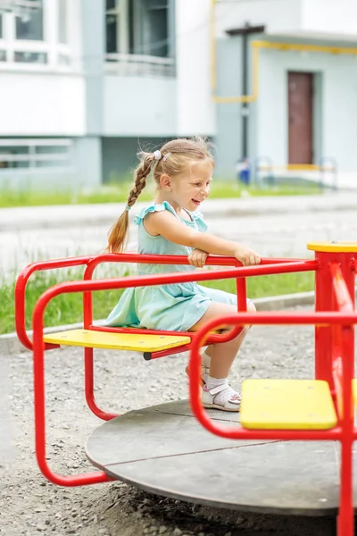 Liten flicka rida på karusellen. Begreppet barndom, livsstil, uppfostran, dagis. — Stockfoto