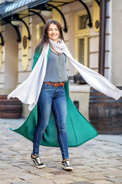 Joven hermosa mujer caminando en la ciudad en una bufanda larga. El concepto de moda, estilo de vida, ciudad — Foto de Stock