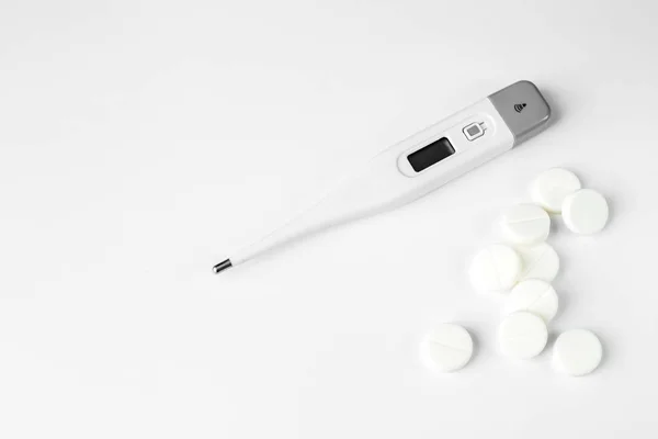 Fehér pills, és hőmérővel. A koncepció a gyógyászat, a betegségek, az egészségügyi. — Stock Fotó
