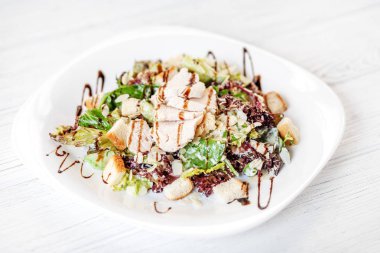 Salatalık ve tavuk ve beyaz zemin üzerine marul salatası.