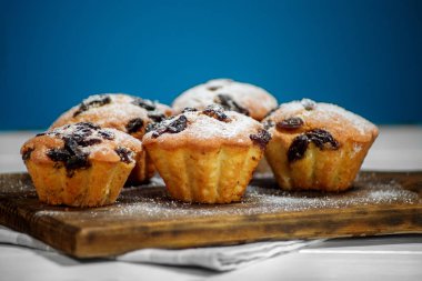 Ahşap tahta üzerinde kuru üzüm ile lezzetli cupcakes. Boşluk Kopyala. Gıda kavramı, hamur işleri, tatlılar.