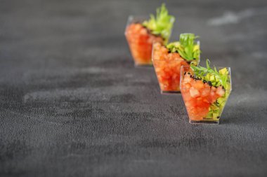 Avokado ve domates ve gri arka planda susam ile lezzetli atıştırmalık. Gıda, diyet ve sağlıklı gıda, restoran ve catering konsepti