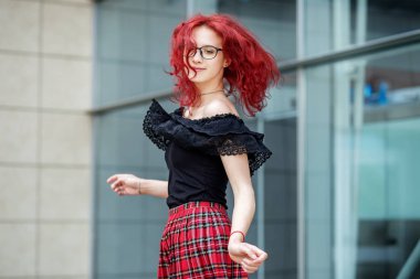 Bir kız sokakta dans ediyor. Kızıl saçlı. Yaşam tarzı kavramı, kentsel, seyahat, moda