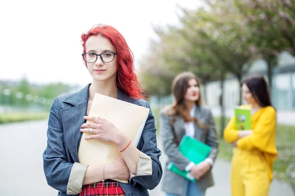 Studentessa brillante con una cartella. Concetto educativo, esami, amicizia e gruppo di persone — Foto Stock