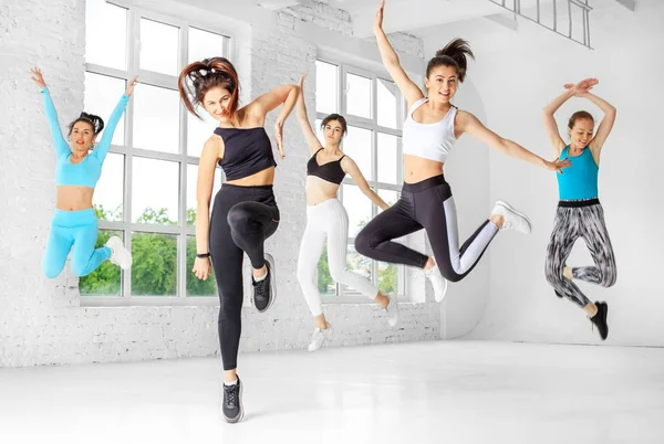 Un groupe de filles sautant pour danser en cours de danse. Le concept de sport, un mode de vie sain, fitness, étirement et danse — Photo