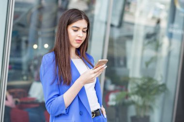 Güzel genç kız bir akıllı telefon üzerinde internet kullanıyor. Moda, iş, iletişim ve yaşam tarzı kavramı