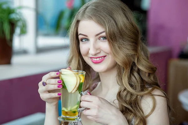 Hermosa mujer bebiendo limonada y sonriendo. Té con menta y cítricos. Concepto de estilo de vida, bebidas y alimentación saludable —  Fotos de Stock