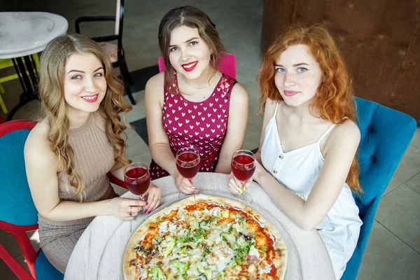 Meeting three girlfriends. Pizza and wine.The concept of food and alcohol, fast food