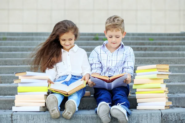 Двоє школярів читають книжки. Концепція повертається до школи, освіти, читання, дружби та сім'ї — стокове фото