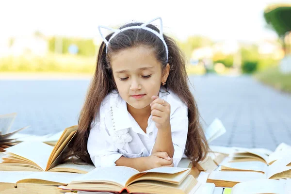 Liten Smart flicka som studerar läroböcker. Konceptet är tillbaka till skolan, utbildning, Läsning, hobbyer. — Stockfoto