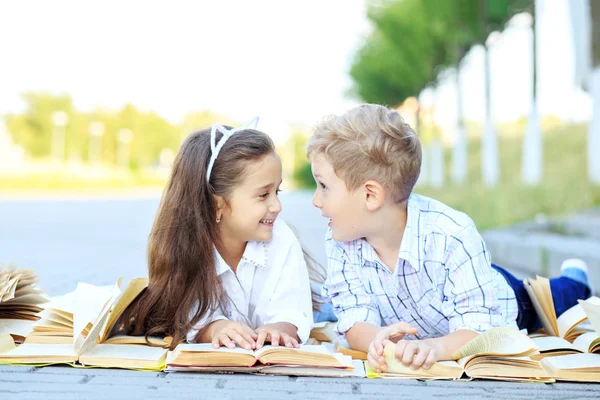 Barn läser, chattar och skrattar. Konceptet är tillbaka till skolan, utbildning, Läsning, vänskap — Stockfoto