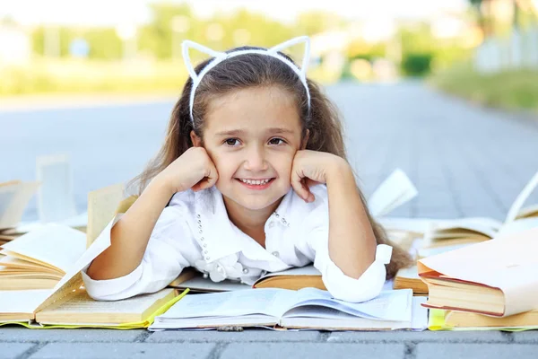 Weinig lachend kind studeren studieboeken. Het concept is terug naar school, onderwijs, lezen, hobby's. — Stockfoto