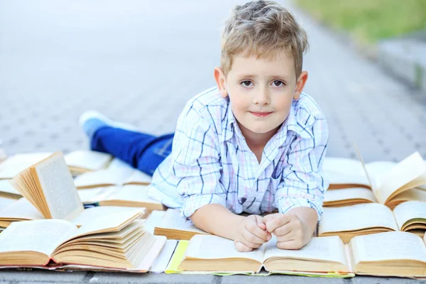 Een klein slim kind studeert studieboeken. Het concept is terug naar school, onderwijs, lezen, hobby's. — Stockfoto