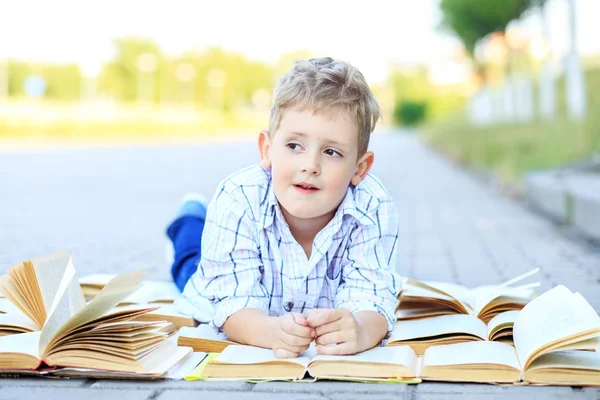 Kleine peinzende jongen studeren studieboeken. Het concept is terug naar school, onderwijs, lezen, hobby's — Stockfoto