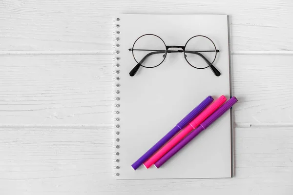 Bloc de notas, gafas y marcadores rosa y púrpura. El concepto de escuela, creatividad, infancia . — Foto de Stock