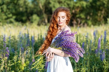 Lupins çiçek bir buket ile güzel bir kız. Konsept yaz, yaşam tarzı, seyahat ve güzellik