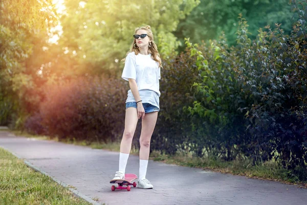 Ευτυχισμένο κορίτσι που καβαλάει σκέιτμπορντ. Η έννοια του τρόπου ζωής, αναψυχή, χόμπι — Φωτογραφία Αρχείου