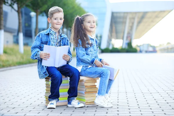 Los pequeños estudiantes leen muchos libros de texto. El concepto es volver a la escuela, la educación, la lectura, la amistad y la familia . —  Fotos de Stock