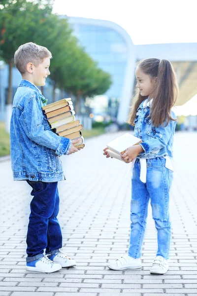 小学生们拿着很多书。这个概念又回到了学校、教育、阅读、友谊和家庭. — 图库照片