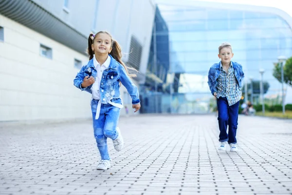 Små barn springer nedför gatan. Begreppet barndom, Familj, utbildning — Stockfoto