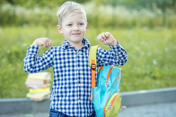 Een sterke school jongen staat met een rugzak. Het concept van leren, school, geest, lifestyle en succes. — Stockfoto