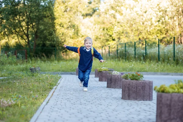 Ein glückliches Kind läuft mit einem Rucksack. das Konzept von Lernen, Schule, Geist, Lebensstil und Erfolg. — Stockfoto