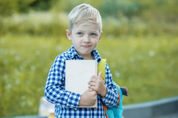 一个淘气的小学生，背着背包和书。学习、学校、思想、生活方式和成功的概念. — 图库照片
