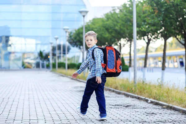 Το αγόρι πηγαίνει στο σχολείο με ένα σακίδιο. Η έννοια της παιδικής ηλικίας, της εκπαίδευσης και του σχολείου — Φωτογραφία Αρχείου