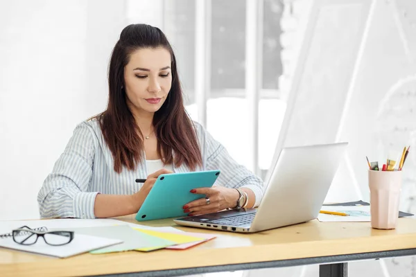 Joven ilustrador dibuja en una tableta en el trabajo. Concepto para negocios, trabajo, carrera . —  Fotos de Stock