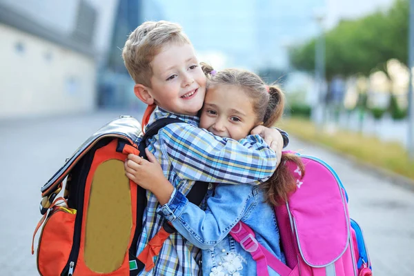 As crianças abraçam e riem. O conceito está de volta à escola, estudo, amizade . — Fotografia de Stock