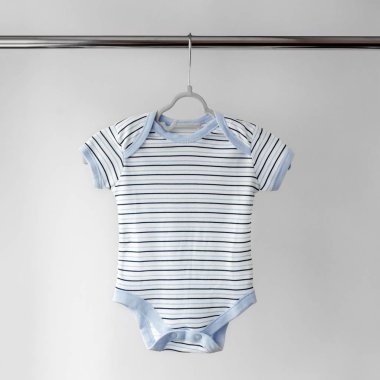 Şeritteki bir bebek için çocuk bodysuit'i. Giysi kavramı, annelik ve yenidoğan.