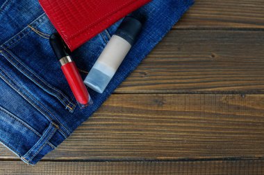 Kot pantolon, makyaj ve debriyaj çantası. Düz yatıyordu. Giyim, aksesuar, alışveriş, iç çamaşırı kavramı.