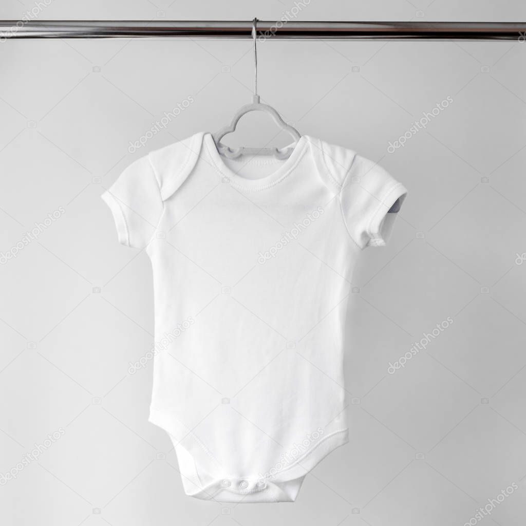 White clean clothes for a newborn on a hanger. The concept of clothes, motherhood, fashion and newborn.