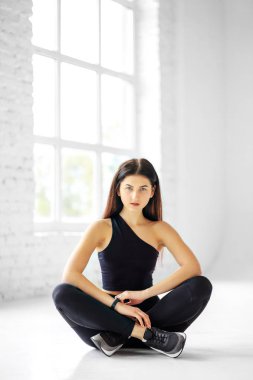 Spor salonundaki genç atletik kız. Dikey. Spor konsepti, sağlıklı yaşam tarzı, fitness.