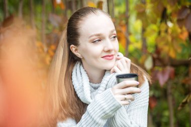 Bir kadın sıcak çay içer ve rüya görür. Sonbahar, yaşam tarzı ve rahatlama kavramı..
