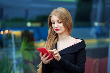 Kız akıllı telefondan bir mesaj yazıyor. Pembe ruj. İnternet, teknoloji, iş, iletişim ve yaşam kavramı.