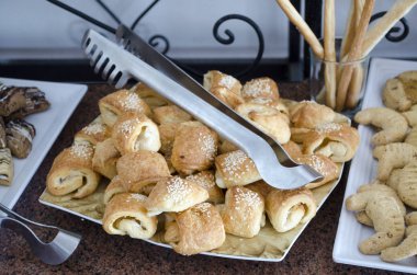 büyük masada tabaklarda tatlı çörekler çeşitli
